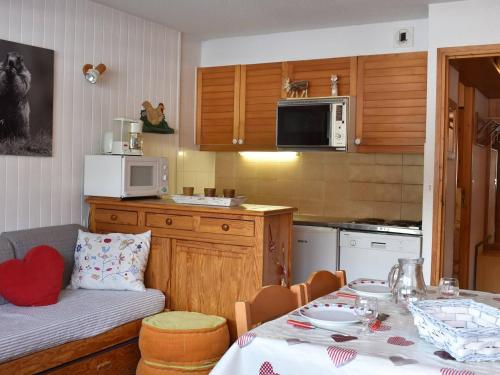 une cuisine avec une table et un canapé ainsi qu'une cuisine avec une table dans l'établissement Studio cosy 4 pers, centre Méribel, pistes à 50m, proche commerces et restos - FR-1-180-312, à Les Allues