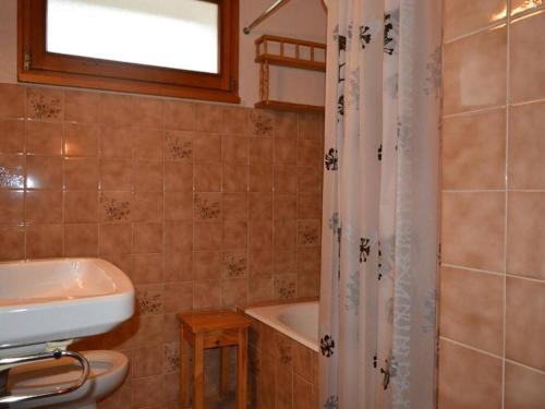 a bathroom with a sink and a toilet and a tub at Appartement Le Grand-Bornand, 2 pièces, 5 personnes - FR-1-241-147 in Le Grand-Bornand