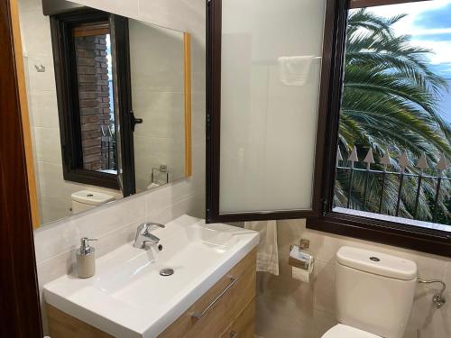 uma casa de banho com um lavatório, um WC e um espelho. em Casa La Nava em Olite