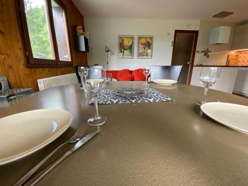 una mesa con dos platos y copas de vino. en Appartement Le Grand-Bornand, 2 pièces, 5 personnes - FR-1-241-142 en Le Grand-Bornand