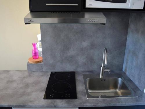 Il comprend une cuisine équipée d'un évier et d'une cuisinière. dans l'établissement Appartement T2 en Front de Mer à Argelès-sur-Mer avec Ascenseur, Animaux Admis, Proche Commerces - FR-1-225-380, à Argelès-sur-Mer