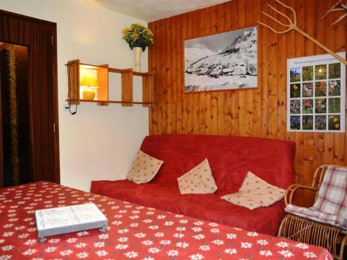 a living room with a red couch and a table at Appartement Le Grand-Bornand, 2 pièces, 6 personnes - FR-1-241-152 in Le Grand-Bornand