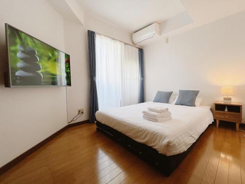a bedroom with a bed with white sheets and a window at PINE TREE HOTEL in Hiroshima
