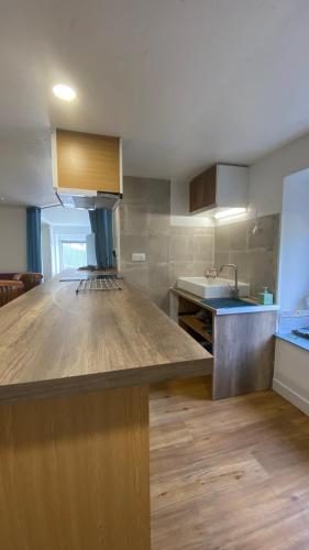 a large kitchen with a large wooden counter top at Gîte du cerisier in Raddon-et-Chapendu