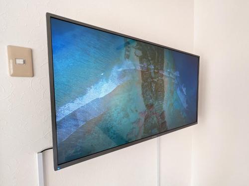 a flat screen tv hanging on a wall at PINE TREE HOTEL in Hiroshima