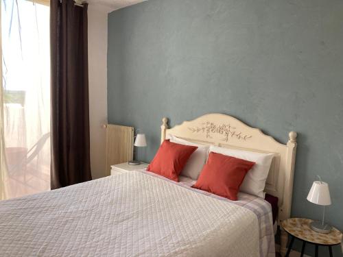 ein Schlafzimmer mit einem Bett mit zwei roten Kissen in der Unterkunft Appartement familial 92m2 avec terrasse vue mer in La Grande-Motte