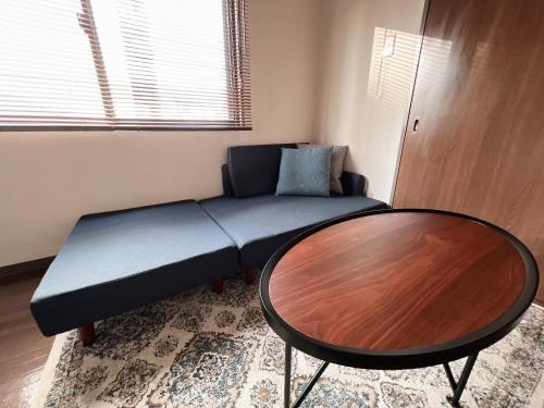 a living room with a couch and a table at PINE TREE HOTEL in Hiroshima