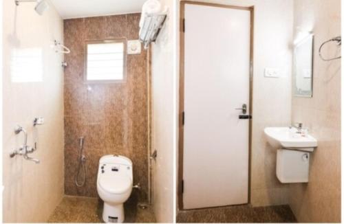 a bathroom with a shower and a toilet and a sink at MM Park Inn in Mahabalipuram