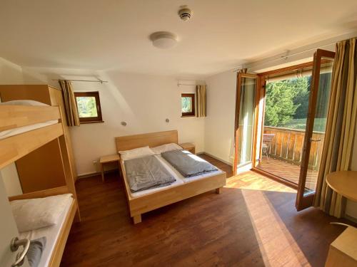 a bedroom with a bed and a balcony at BLSV Sportcamp direkt im Wandergebiet Spitzingsee in Schliersee