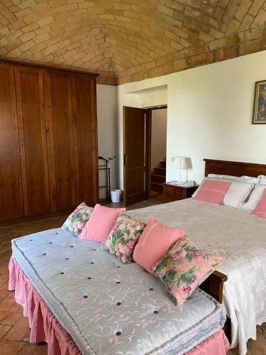 a bedroom with a large bed with pink pillows at Torre Colombaia in Salsomaggiore Terme