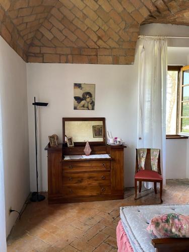 a bedroom with a wooden dresser and a mirror at Torre Colombaia in Salsomaggiore Terme