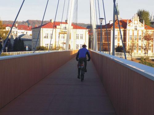 a person riding a bike on a bridge at TALIA Apartament Tatarska 4 in Przemyśl