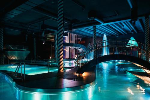 una piscina con ponte in una città di notte di Holiday Club Saimaa Apartments a Imatra