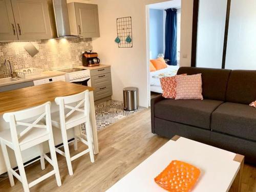 a kitchen and a living room with a couch and a table at F2 calme, Château, Grand Parquet, Fôret in Avon