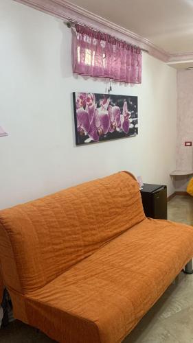 a bedroom with a bed with an orange blanket at Capri Dreaming in Anacapri