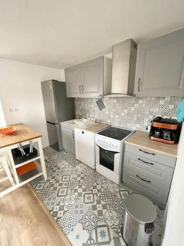 une cuisine avec des armoires blanches et un sol carrelé dans l'établissement F2 calme, Château, Grand Parquet, Fôret, à Avon