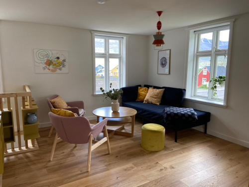 a living room with a blue couch and a table at Steinholt, charming & just renovated apartment ! in Seyðisfjörður