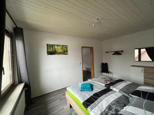 a bedroom with a bed with a blue bag on it at Ferienwohnung am grünen Haus in Garz