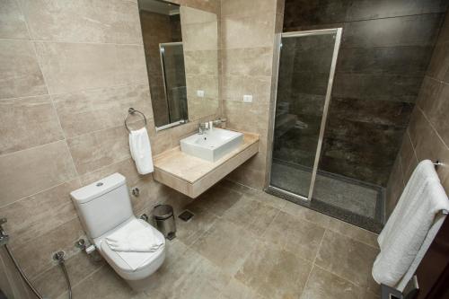 a bathroom with a toilet and a sink and a shower at AIFU Hotel El Montazah Alexandria in Alexandria