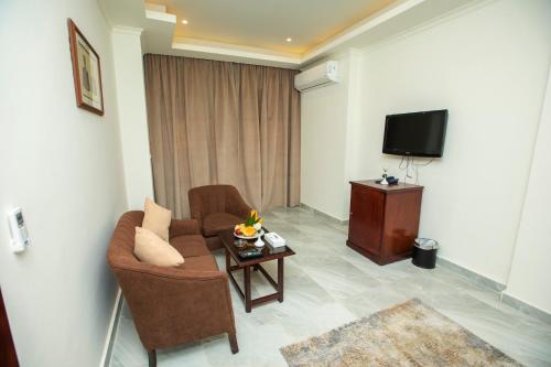 a living room with a couch and a tv at AIFU Hotel El Montazah Alexandria in Alexandria