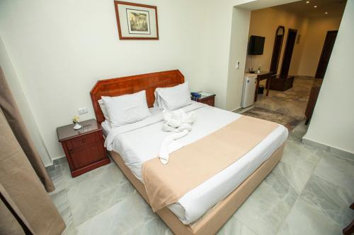a bedroom with a white cat sitting on a bed at AIFU Hotel El Montazah Alexandria in Alexandria