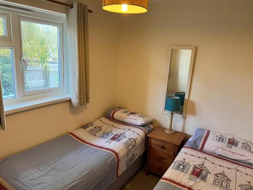 sypialnia z 2 łóżkami i lustrem w obiekcie 2 Bedroom Bungalow SV58, Seaview, Isle of Wight Free Wi-Fi w mieście Seaview