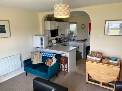 a kitchen with a blue couch and a blue chair at 2 Bedroom Bungalow SV58, Seaview, Isle of Wight Free Wi-Fi in Seaview