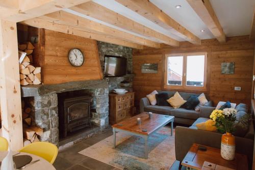 a living room with a fireplace and a couch at Chalet Dranse Winter Ski Summer Vtt Hot Tubsauna in Saint-Jean-dʼAulps