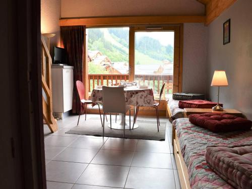 d'un salon avec une table et un balcon. dans l'établissement Studio mezzanine 5 pers avec balcon sud, cœur Méribel, proche pistes et commerces - FR-1-180-304, à Méribel