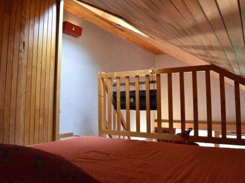 sypialnia z łóżkiem i drewnianymi schodami w obiekcie Appartement Méribel, 1 pièce, 5 personnes - FR-1-180-304 w Méribel