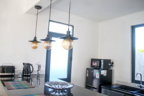 a kitchen with three lights hanging over a counter at Shany’s Villa 3bdrm with private swimming pool in Mombasa