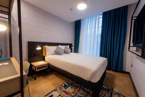 a hotel room with a bed and a window at The Wesley Camden Town in London