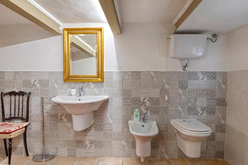 y baño con lavabo, aseo y espejo. en Villa Egola, en San Miniato