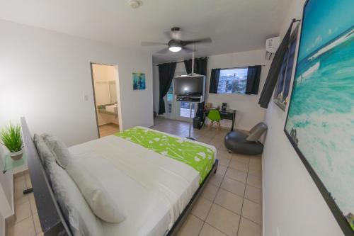 a bedroom with a bed and a tv in it at Casa Verde Hotel - Steps to the Beach, Pool, Restaurant & Bar in Rincon