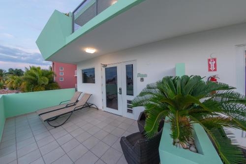 a balcony of a house with a chair and a plant at Casa Verde Hotel - Steps to the Beach, Pool, Restaurant & Bar in Rincon