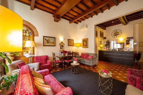 a living room with red couches and a dining room at Hotel Maxim Axial in Florence
