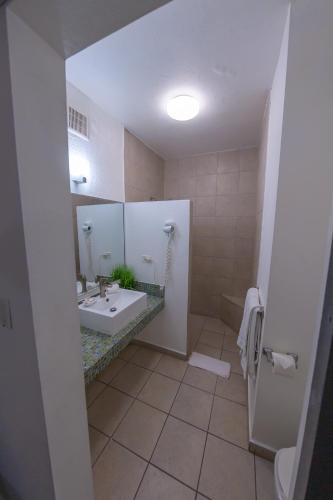a bathroom with a sink and a mirror at Casa Verde Hotel - Steps to the Beach, Pool, Restaurant & Bar in Rincon