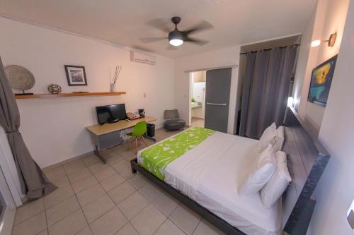 a bedroom with a bed and a desk with a computer at Casa Verde Hotel - Steps to the Beach, Pool, Restaurant & Bar in Rincon