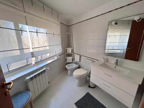 een witte badkamer met een toilet en een wastafel bij Casa Terrazza del Sole in Catania