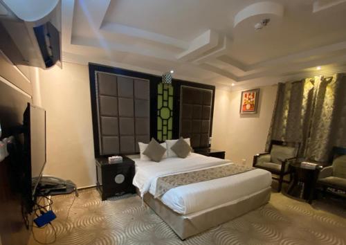 a bedroom with a bed and a couch and a television at Golden New Al Dar - جولدن نيو الدار in Jazan