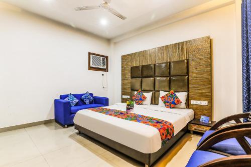 a bedroom with a large bed and a blue couch at FabHotel The Residency DLF Galleria in Gurgaon