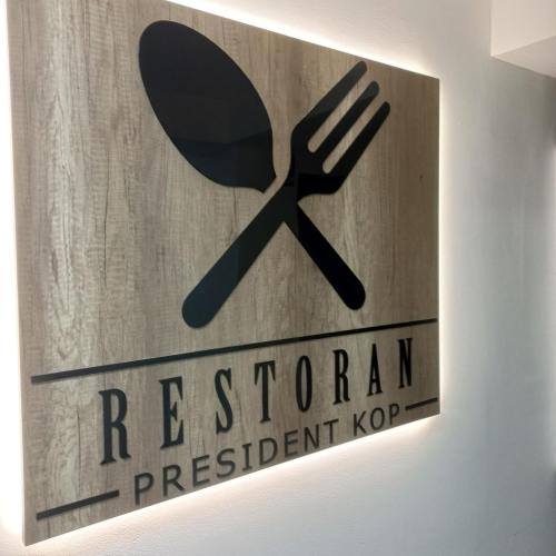 a sign for a restaurant with a spoon and fork at President KOP A515 in Kopaonik