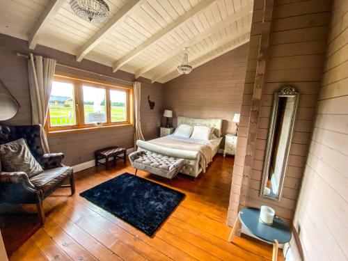 a bedroom with a bed and a chair and a window at Beautiful 3-Bed Luxury Private Lodge in York in York