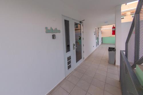 a hallway of a hospital with a door and tile floor at Casa Verde Hotel - Steps to the Beach, Pool, Restaurant & Bar in Rincon