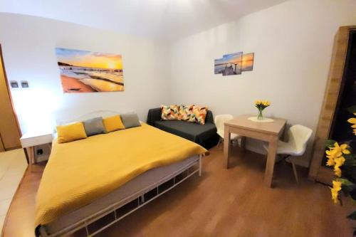 a bedroom with a bed and a couch and a table at Cozy modern Apartment SUNRISE studio 35m2 balcony 3 persons in Krakow