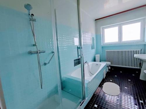 a bathroom with a shower and a tub and a sink at Villa Sainte-Rose 3ch à 5 minutes de la Cité des Loisirs in Amnéville