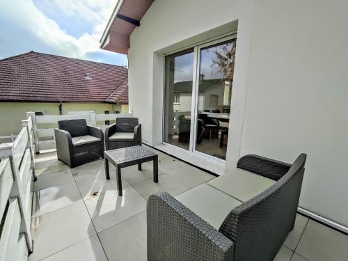 un patio avec des chaises et une table sur un balcon dans l'établissement Villa Sainte-Rose 3ch à 5 minutes de la Cité des Loisirs, à Amnéville