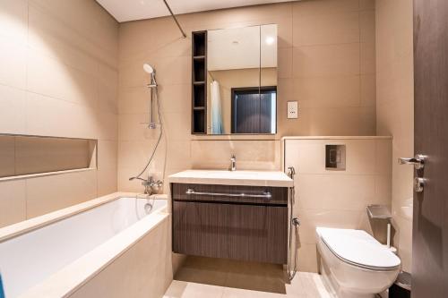 uma casa de banho com uma banheira, um lavatório e um WC. em Luxury StayCation - Fancy Apartment Connected To Burj Khalifa em Dubai