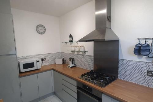 a kitchen with a stove top oven next to a microwave at Charming flat near Shoreditch in London