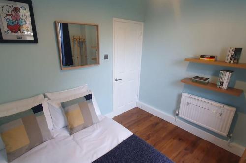a bedroom with a bed with a mirror and a door at Charming flat near Shoreditch in London